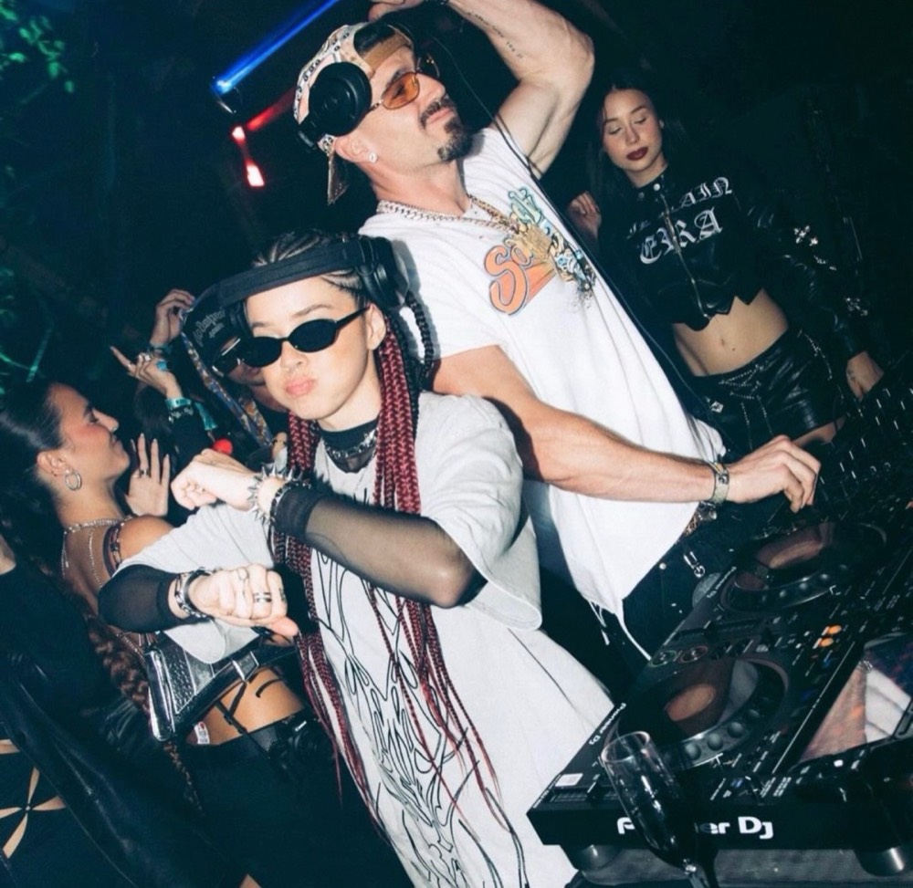 Two DJs behind the decks in a packed club