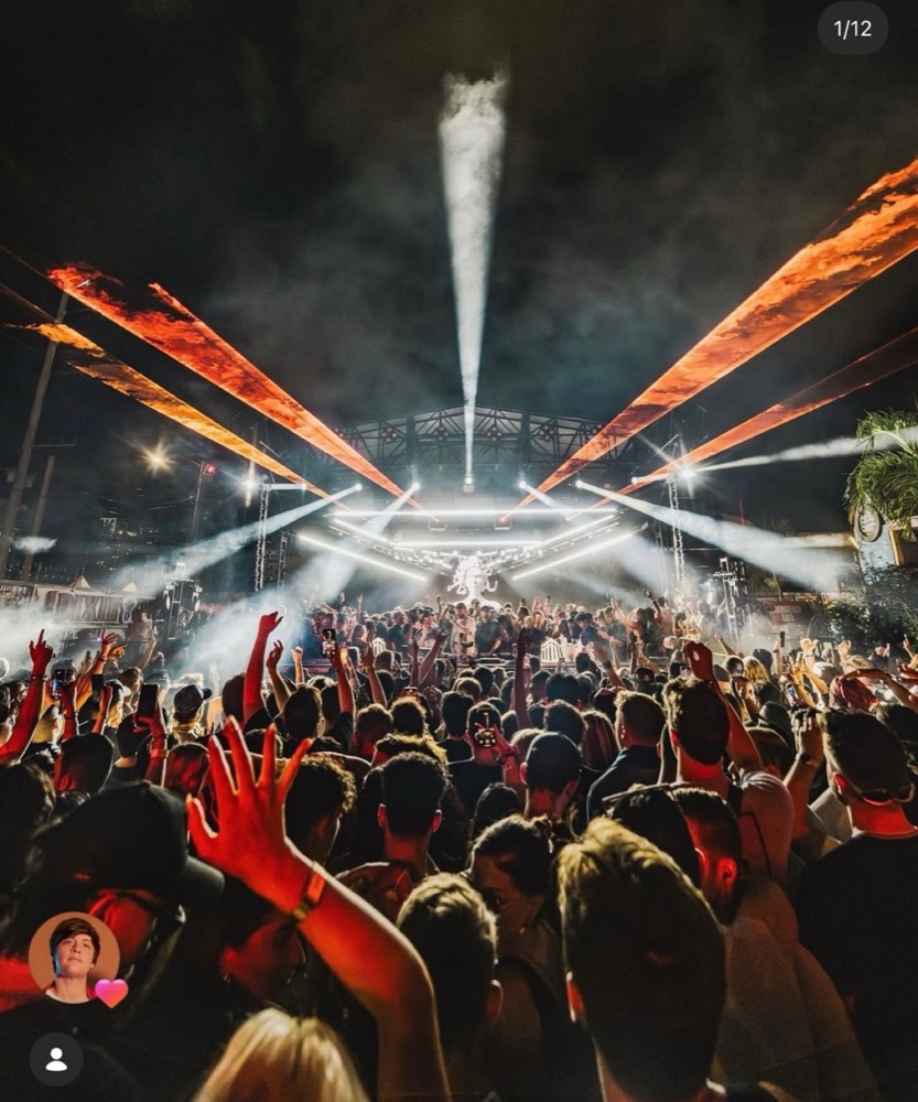 Lasers and CO2 over a packed outdoor crowd facing the stage