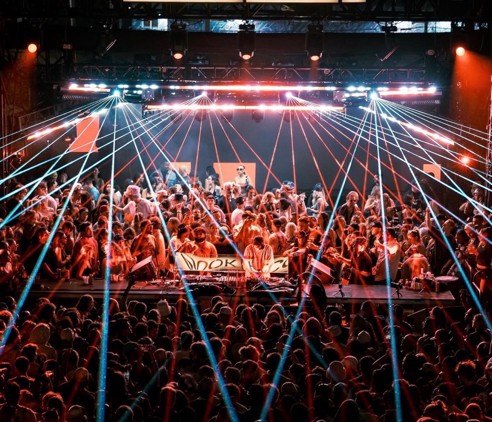Red and blue lasers fanning out over a packed crowd around the DJ booth